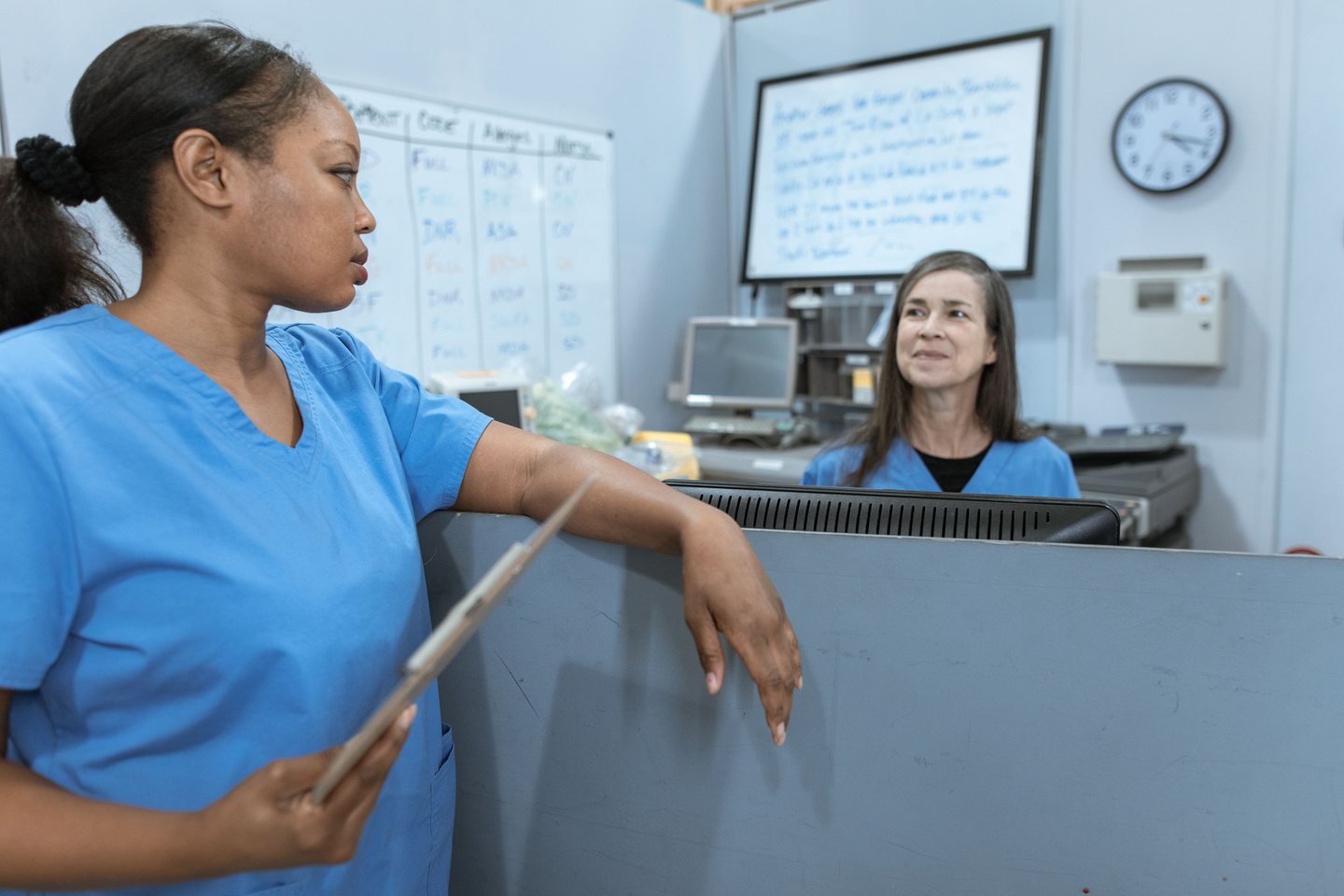 Nursing professionals discussing clinical work with a clipboard