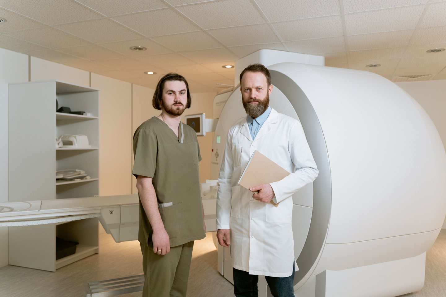 Healthcare professionals standing beside an MRI scanner